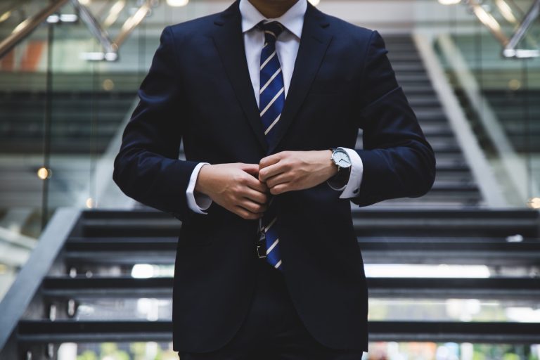 Professional in business suit descends stairs in office building