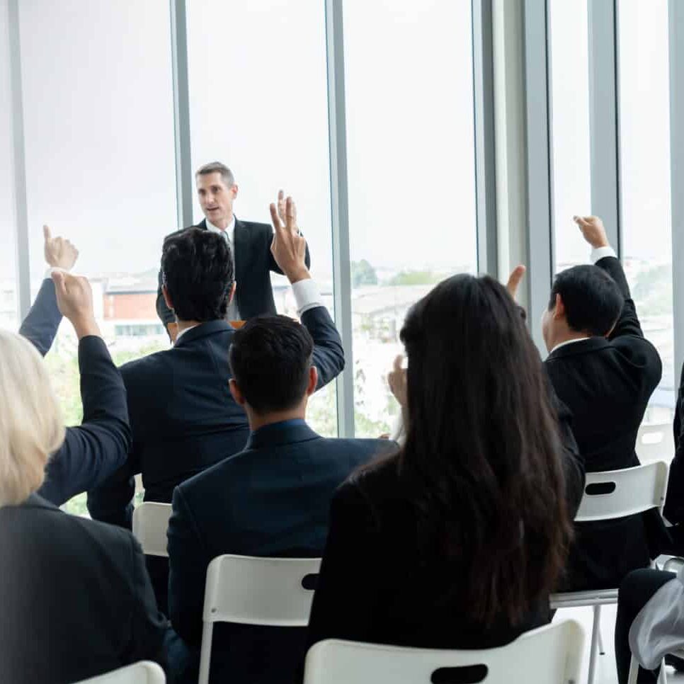 group of professionals in training raising hands